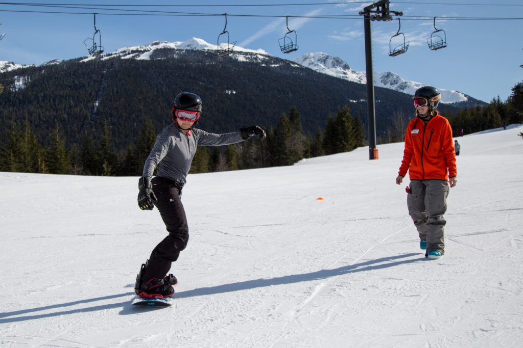 A beginner snowboarder practises