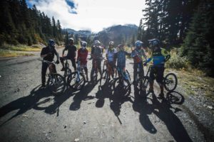 A group of people on mountain bikes talk and laugh together